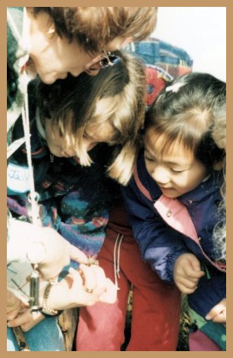 Guide showing bug to two amazed little girls